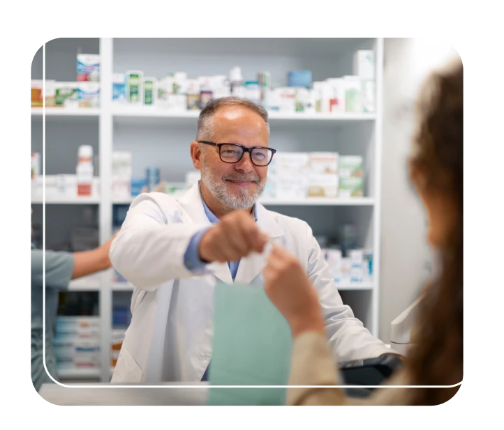 Smiling pharmacist handing medication to client.